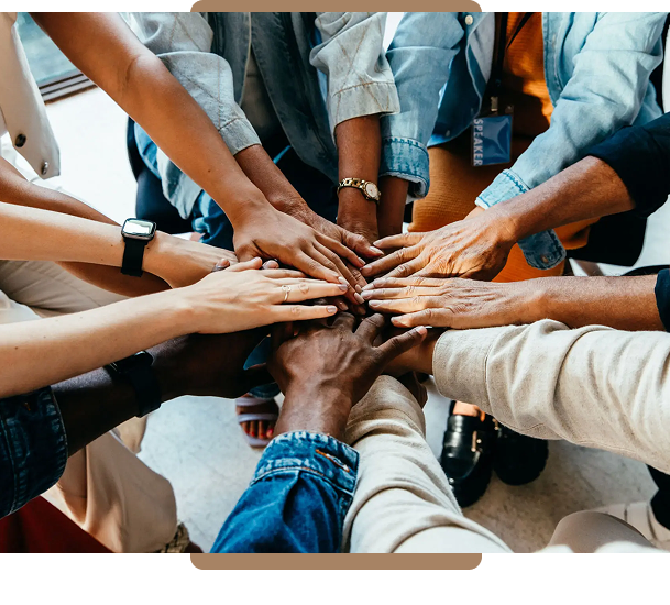 Diverse group joining hands in unity and teamwork.