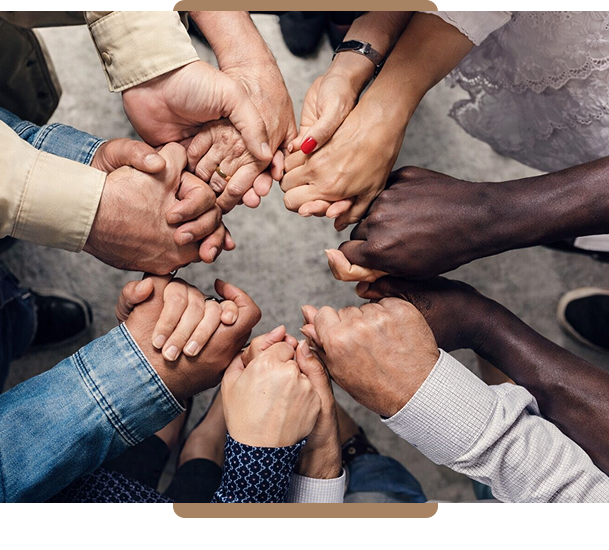Diverse group of people joining hands in unity.