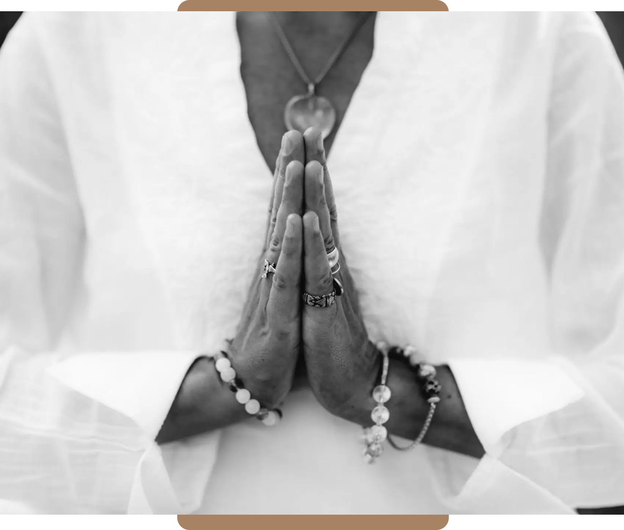 Hands joined in prayer with rosary beads.