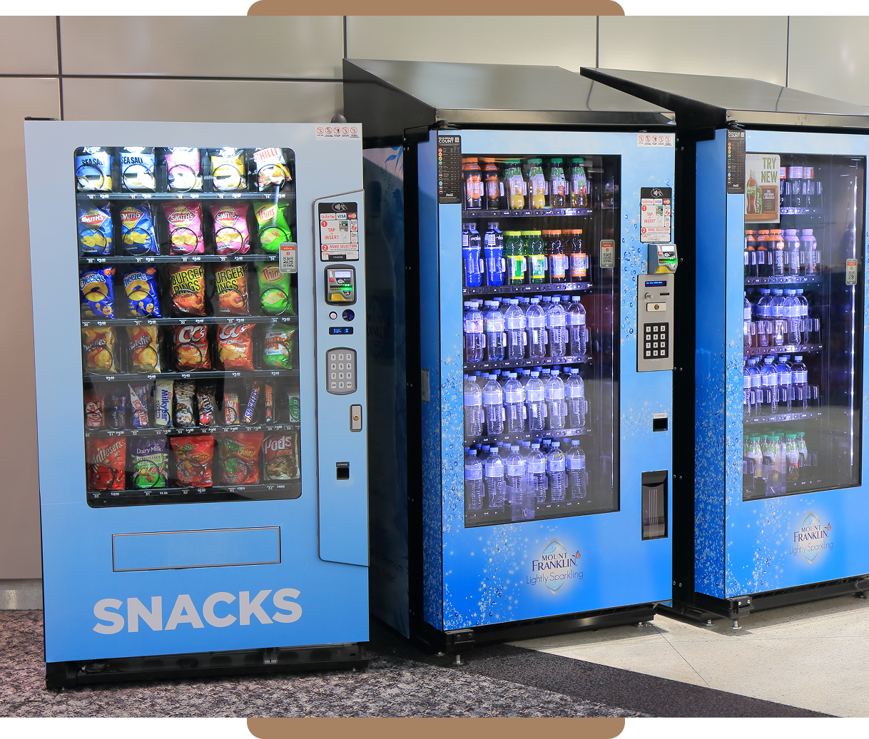 Three vending machines offering snacks and drinks in a row.