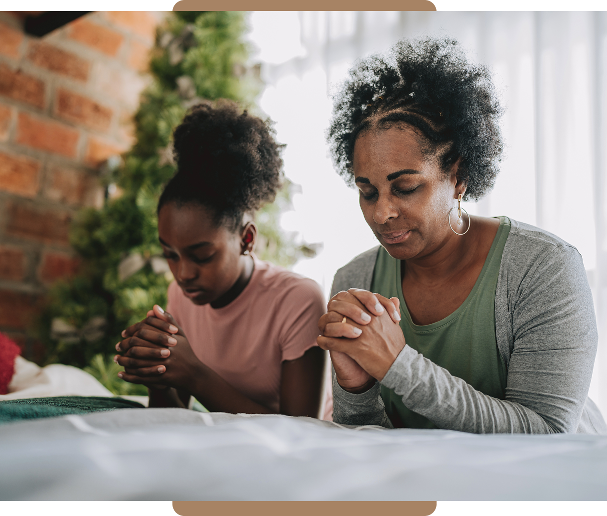 Mother and daughter praying together at home.